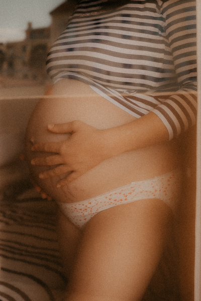 main femme enceinte caresse son ventre nu