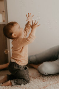 un bebe joue avec des bulles de savon a la maison