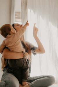 une jeune maman et son bebe regardent les bulles de savon voler