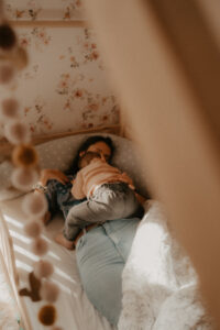 une maman allaite son bebe allongee dans lit cabane