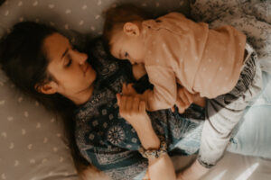 un bebe tete allonge sur sa maman