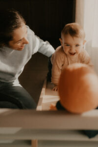 un bebe joue a la poupee dans le salon