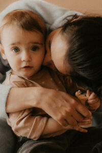 une maman embrasse son bebe et lui fait un calon