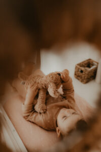 reflet dans le miroir de bebe qui joue avec un doudou