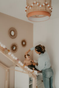 une maman coiffe son bebe sur la table a langer