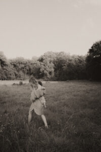 une maman marche son bebe dans les bras dans un champs a vaugrenier