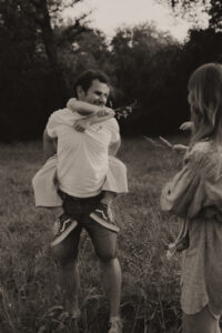 un papa porte sa fille sur son dos dans les champs