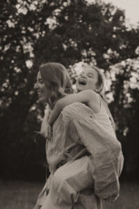 une maman porte sa fille sur son dos en foret