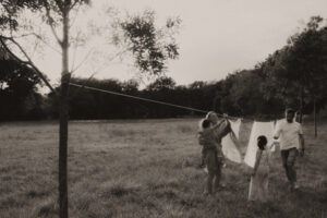 une famille etend le linge dans le jardin