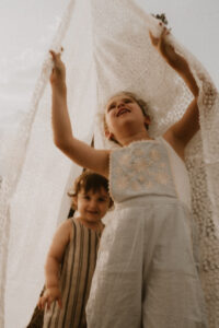 un frere et sa soeur se cache dans le linge etendu dans le jardin
