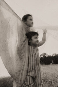 un frere et une soeur jouent dans les draps