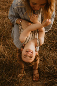 une maman chatouille son petit garcon dans ses bras