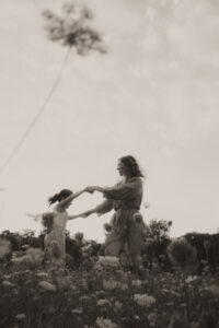 une maman et sa fille dansent dans un champs de fleurs à vaugrenier