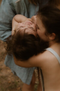 une grande soeur fait un bisou a son petit frere