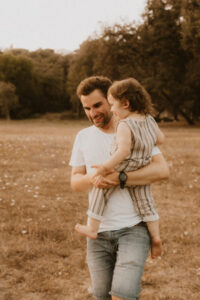 un papa porte son fils dans un parc naturel de vaugrenier
