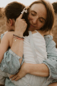 une maman sert sa fille contre elle