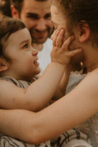 une petit garcon prend le visage de sa soeur entre les mains