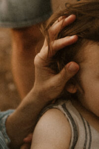 la main de maman caresse les cheveux de son petit garcon