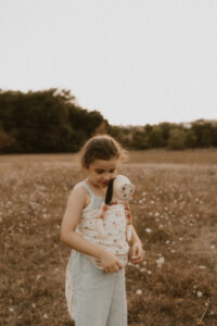 une petite fille porte poupee pipouette en portage