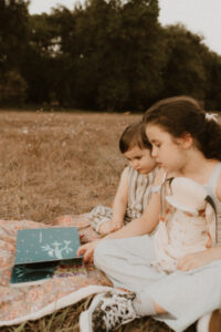 deux enfants lisent une histoire dans herbe