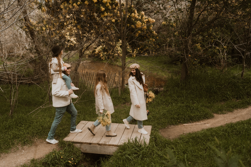 en seance photo lifestyle la famille marche sur un pont de bois dans la foret