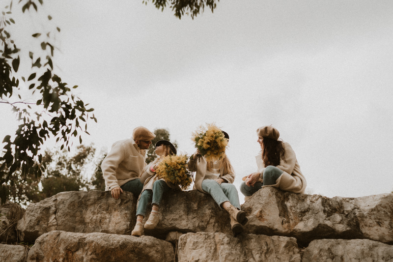 une famille assise sur les rochers sans pose pendant leur seance photo en exterieur