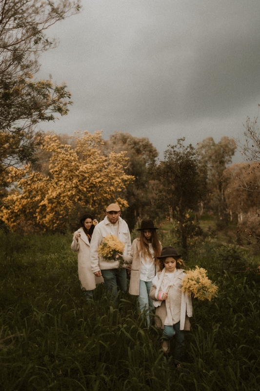 une famille marche et joue dans la nature en seance photo lifestyle