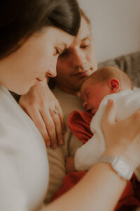 durant la seance photo lifestyle le photographe naissance laisse les parents caliner leur bebe sur le canape de leur domicile