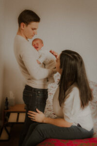 pendant la seance photo lifestyle on prend des photos de bebe qui pleure caline par ses parents