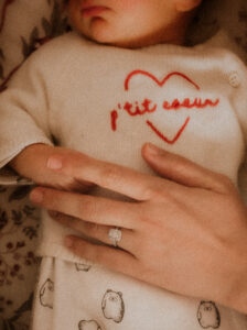 photo de details maman caresse la main de son nouveau-ne pendant leur seance photo naissance