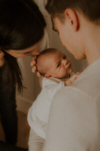 pendant la seance photo naissance lifestyle la famille ne pose pas mais caline leur bebe comme il le font tous les jours