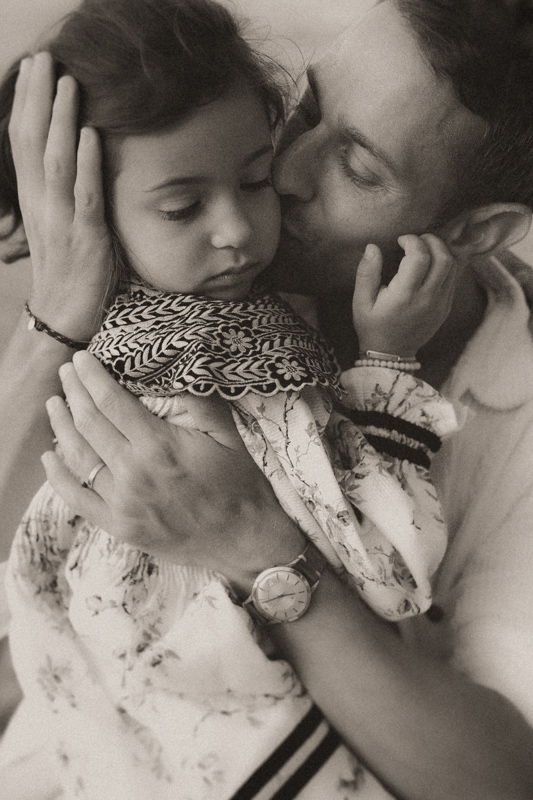 papa embrasse sa fille pour une photo naturelle remplie de tendresse