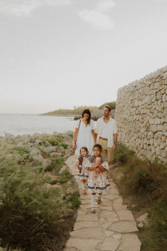 une famille marche sur le sentier du littoral pendant seance photo lifestyle au coucher du soleil