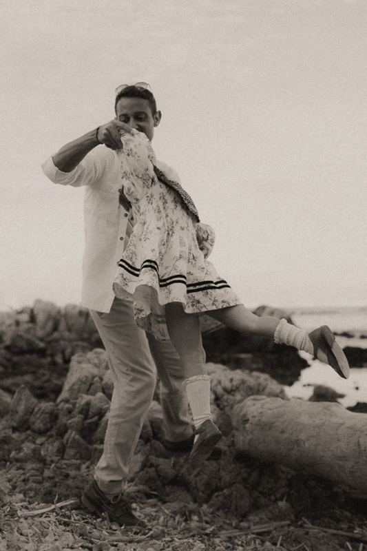 photographe famille demande au papa d'aider sa fille a sauter en l'air sur la plage cap antibes