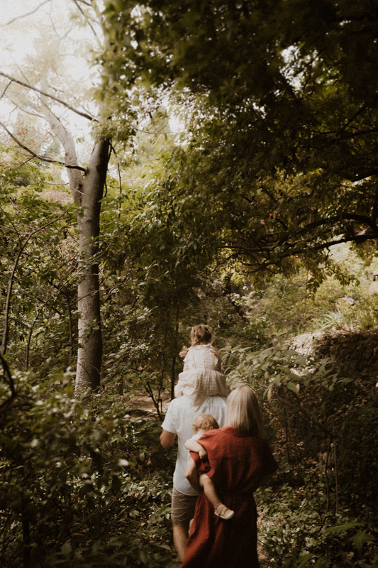 une famille marche sur un sentier dans la nature les enfants aux bras durant seance photo lifestyle
