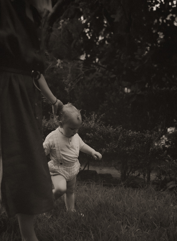 une bebe marche dans l'herbe avec sa maman pendant seance photo famille dans les jardins des alpes-maritimes