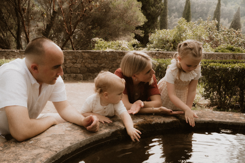 en seance photo famille alpes-maritimes une famille joue autour de la fontaine du jardin