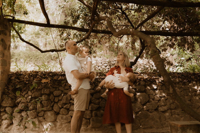 les parents portent et allaitent leurs enfants pendant seance photo dans un jardin