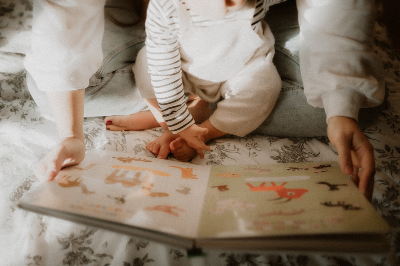 maman et bebe lisent un livre sur le lit en seance maternite lifestyle a cannes