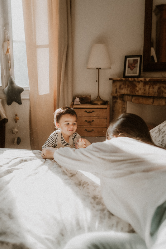 en seance maternite avec marguerite photographe a cannes maman et bebe jouent sur le lit