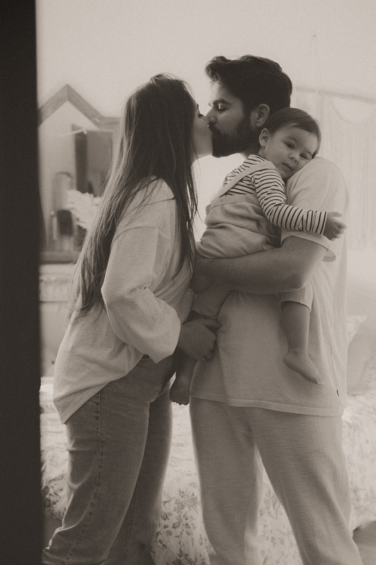 couple s'embrassent avec bebe dans les bras en seance photo lifestyle a cannes
