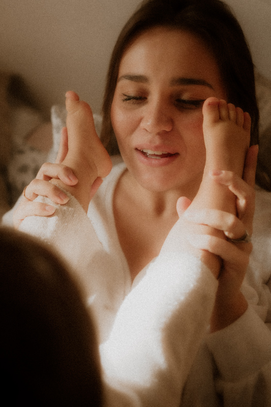 maman joue avec les pieds de bebe en seance photo maternite lifestyle a cannes