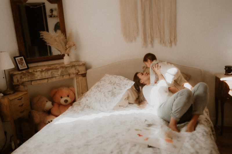 maman et bebe joue sur le lit en seance photo maternite a domicile a cannes