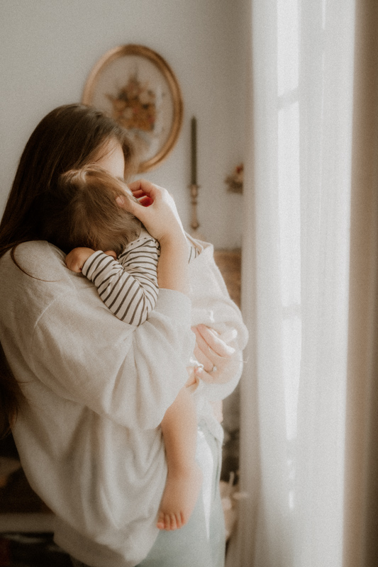 maman caline bebe dans les bras en seance photo maternite a domicile a cannes