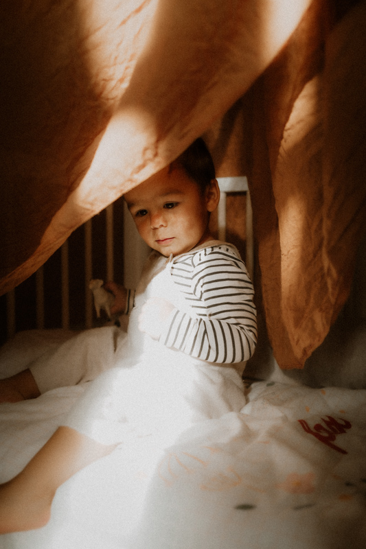 bebe cache dans le lit en seance photo a domicile a cannes