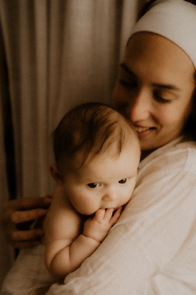 bebe dans les bras pour des photos de maternite naturelles