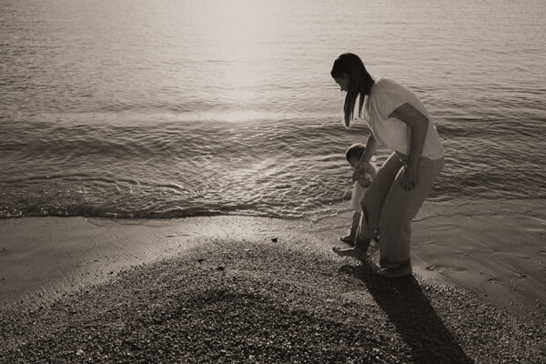une maman et son bebe marche au bord de l eau sur la plage des sablettes de menton