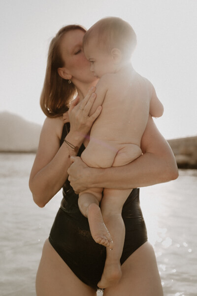 une maman tient son bebe dans les bras dans la mer de menton