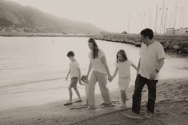 une famille coure en se tenant la main sur la plage des sablettes de menton