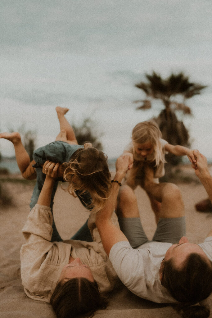 en seance photo famille les enfants rient et jouent avec les parents sur la plage de saint aygulf